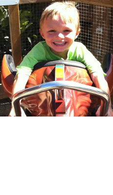 Smiling male student leans over a carnival ride